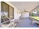 Large, screened porch with ceiling fan and seating area, perfect for enjoying the outdoors in comfort at 35128 Dale Ave, Zephyrhills, FL 33541