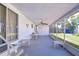 Large, screened porch with ceiling fan and seating area, perfect for enjoying the outdoors in comfort at 35128 Dale Ave, Zephyrhills, FL 33541