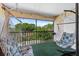 Charming balcony with hammock chairs, string lights, privacy screens, and green outdoor carpet at 3600 Magnolia Ridge Cir # 1221-G, Palm Harbor, FL 34684