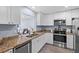Modern kitchen features white cabinets, granite counters, and stainless steel appliances. Open layout at 3600 Magnolia Ridge Cir # 1221-G, Palm Harbor, FL 34684