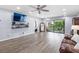 Spacious living room with updated flooring, large screen TV, and sliding glass doors to the balcony at 3600 Magnolia Ridge Cir # 1221-G, Palm Harbor, FL 34684