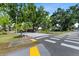 Street view approaching the community with lush trees and manicured landscaping at 3600 Magnolia Ridge Cir # 1221-G, Palm Harbor, FL 34684