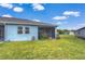Backyard with a well-maintained lawn, a screened patio area, and a light-blue painted home exterior at 3765 Maxwell Park Dr, Sun City Center, FL 33573