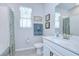 Bright bathroom featuring tiled floors, white vanity with marble countertop, and shower with colorful floral curtain at 3765 Maxwell Park Dr, Sun City Center, FL 33573