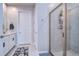 Tiled bathroom with a glass-enclosed shower and a vanity with a marble countertop at 3765 Maxwell Park Dr, Sun City Center, FL 33573
