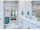 Bright bathroom featuring double vanity sinks, granite counters and a view into the bedroom at 3765 Maxwell Park Dr, Sun City Center, FL 33573