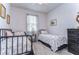 Cozy bedroom with two twin beds, neutral bedding, a window with curtains, and a dark wood dresser at 3765 Maxwell Park Dr, Sun City Center, FL 33573