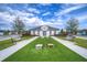 Community clubhouse with green space, cornhole, benches and beautiful landscaping at 3765 Maxwell Park Dr, Sun City Center, FL 33573
