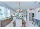 Open-concept dining room flowing into living area, featuring stylish furniture and abundant natural light at 3765 Maxwell Park Dr, Sun City Center, FL 33573
