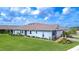 Charming single-story home with lush green lawn and well-manicured landscaping under a bright blue sky at 3765 Maxwell Park Dr, Sun City Center, FL 33573
