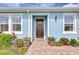 Charming front entrance with decorative wreath and potted plants, leading up to a welcoming dark-colored door at 3765 Maxwell Park Dr, Sun City Center, FL 33573