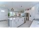 Bright open-concept kitchen with white cabinets, large island, and stainless steel appliances at 3765 Maxwell Park Dr, Sun City Center, FL 33573