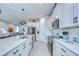 Modern kitchen featuring white cabinets, stainless steel appliances, and a breakfast bar overlooking the living space at 3765 Maxwell Park Dr, Sun City Center, FL 33573
