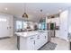 Modern kitchen with a white quartz island, pendant lighting and stainless steel appliances at 3765 Maxwell Park Dr, Sun City Center, FL 33573