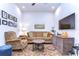 Cozy living room with a brown sofa, patterned armchair, area rug, TV, and decorative elements at 3765 Maxwell Park Dr, Sun City Center, FL 33573