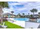 Community swimming pool with lounge chairs, palm trees and outdoor grill at 3765 Maxwell Park Dr, Sun City Center, FL 33573