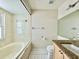 Bright bathroom featuring a tiled bathtub, toilet, and granite countertop vanity at 3944 102Nd N Pl, Clearwater, FL 33762