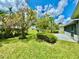 Well-manicured front yard features lush green grass and mature trees, enhancing the curb appeal of this home at 3944 102Nd N Pl, Clearwater, FL 33762