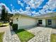 Side exterior view featuring a paved walkway, green lawn, and a cozy outdoor seating area with view of the sky at 3944 102Nd N Pl, Clearwater, FL 33762