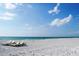 Expansive white sand beach with lounge chairs and clear turquoise water at 399 C 2Nd St # 313, Indian Rocks Beach, FL 33785