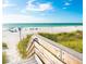 Beach access with stairs over looking the white sands and aqua water on a beautiful sunny day at 399 C 2Nd St # 313, Indian Rocks Beach, FL 33785