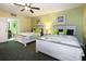 Bright bedroom featuring two beds with coastal-themed bedding and a ceiling fan at 399 2Nd St # 313, Indian Rocks Beach, FL 33785