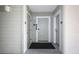 Condo hallway featuring a gray door, blue unit number, and a sleek black welcome mat at 399 C 2Nd St # 313, Indian Rocks Beach, FL 33785