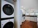 Convenient laundry area featuring a modern stacked washer and dryer, adjacent to the bright and stylish kitchen at 399 2Nd St # 313, Indian Rocks Beach, FL 33785