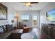 Inviting living room includes a ceiling fan, leather seating, and access to a balcony at 399 C 2Nd St # 313, Indian Rocks Beach, FL 33785