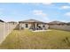 A spacious backyard with a manicured lawn, privacy fence, and patio furniture for outdoor entertaining at 4025 Capri Coast Dr, Plant City, FL 33565