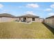 A large backyard features a manicured lawn, privacy fence, and patio furniture for outdoor relaxation at 4025 Capri Coast Dr, Plant City, FL 33565