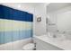 The bathroom is featuring a vanity with modern fixtures, and a tub/shower with a bright shower curtain at 4025 Capri Coast Dr, Plant City, FL 33565