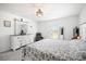 A well-lit bedroom is decorated with a white dresser, mirror, a large bed, and a comfortable chair at 4025 Capri Coast Dr, Plant City, FL 33565