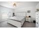 Bright bedroom featuring a large window, neutral walls, and a stylish white and wood bed frame at 4025 Capri Coast Dr, Plant City, FL 33565