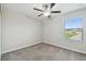 This bedroom has neutral walls, ceiling fan, carpet, and a window for ample natural light at 4183 Ballantrae Blvd, Land O Lakes, FL 34638