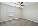 This bedroom has carpet, neutral walls, a ceiling fan, and a window providing great natural light at 4183 Ballantrae Blvd, Land O Lakes, FL 34638