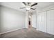 This bedroom features neutral walls, carpet, ceiling fan, closet, and an entry to a bathroom at 4183 Ballantrae Blvd, Land O Lakes, FL 34638