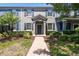 Charming townhome featuring a landscaped yard with a paver walkway, inviting curb appeal, and a covered entryway at 4183 Ballantrae Blvd, Land O Lakes, FL 34638