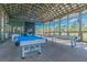 Bright game room featuring multiple pool tables under a vaulted, exposed-beam ceiling with outdoor views at 4183 Ballantrae Blvd, Land O Lakes, FL 34638