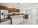 Modern kitchen featuring stainless steel appliances, a center island, and granite counters with an adjacent living space at 4183 Ballantrae Blvd, Land O Lakes, FL 34638