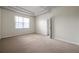 Spacious bedroom featuring plush carpeting, tray ceiling and a window allowing for lots of natural light at 4500 Fieldview Cir, Wesley Chapel, FL 33545