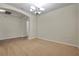 Dining room with carpet and chandelier leading to another room with wood-look floors at 4500 Fieldview Cir, Wesley Chapel, FL 33545