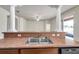Open kitchen with stainless sink, breakfast bar, white pillars, and a view to the living area at 4500 Fieldview Cir, Wesley Chapel, FL 33545