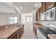 Open kitchen featuring a breakfast bar, stainless steel appliances, and tile flooring, with views to the dining area at 4500 Fieldview Cir, Wesley Chapel, FL 33545
