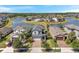 Aerial view of homes with well-maintained yards, surrounded by a picturesque lake and green spaces at 4719 Tramanto Ln, Wesley Chapel, FL 33543