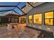 A well-appointed, covered patio space is illuminated by recessed lighting and offers outdoor dining at 4719 Tramanto Ln, Wesley Chapel, FL 33543