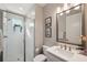 Modern bathroom boasts walk-in shower with glass door, stylish fixtures and decorative hanging plants at 4719 Tramanto Ln, Wesley Chapel, FL 33543