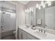 Bright bathroom featuring double vanity, quartz countertop and bathtub with tiled shower at 4719 Tramanto Ln, Wesley Chapel, FL 33543