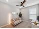 Cozy bedroom with a comfortable sofa, accent wall decor, and a modern ceiling fan, perfect for relaxing or as an office space at 4719 Tramanto Ln, Wesley Chapel, FL 33543