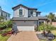 Charming two-story home featuring a brick driveway, two-car garage, and beautifully landscaped front yard at 4719 Tramanto Ln, Wesley Chapel, FL 33543
